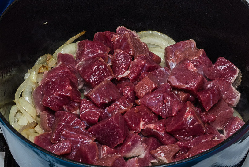 Рецепт венгерского гуляша из говядины. Говядина по венгерски. Гуляш из говядины по-венгерски. Кусочки теста а сверху мясо с луком. Как порезать мясо на гуляш.